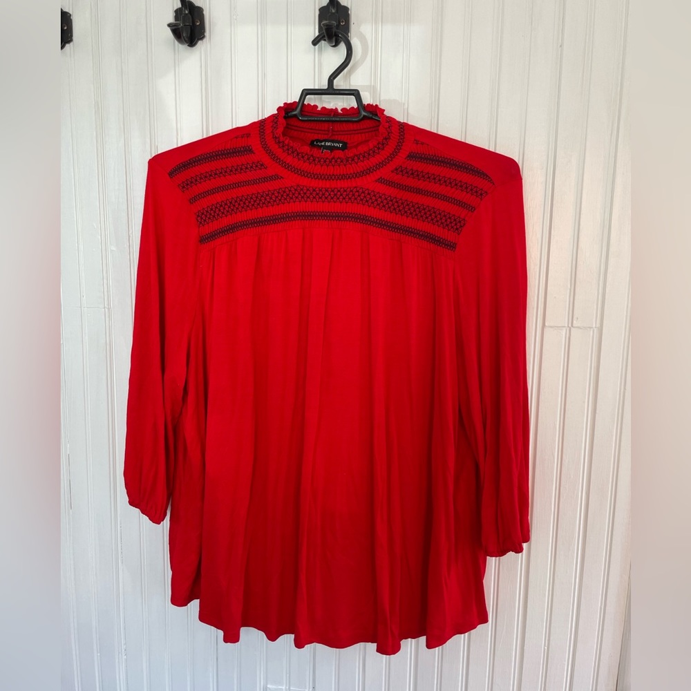 High neck blouse. Red with black embellishment.